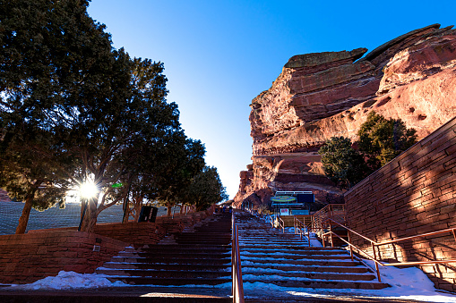 Morrison, Colorado, USA, February 2, 2023, Afternoon sun shining on Ship Rock of Red Rocks Amphitheater with snow covered stairs leading upward