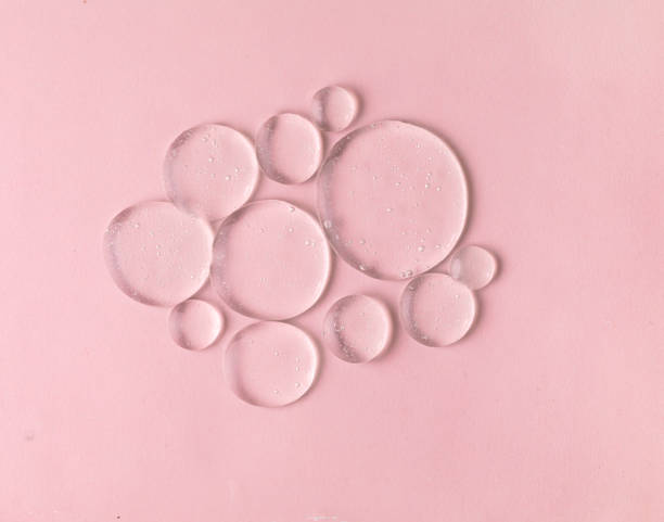 istock Cosmetic lotion transparent gel drops texture background, pink 1465720500