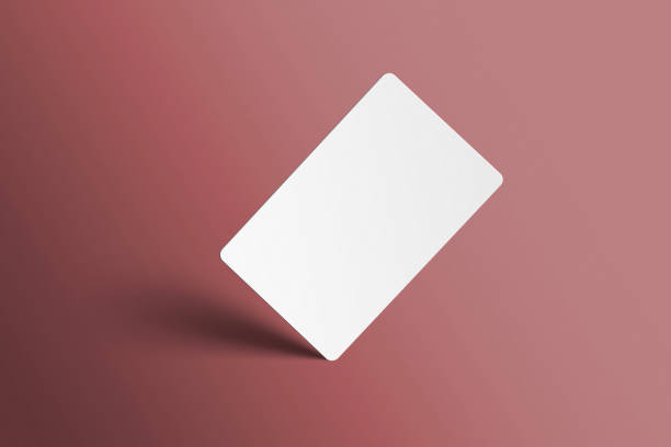 istock Blank mockup of a universal gift card in a studio light red background standing on the corner with shadows. Readymade showcase 3D render. Invite, identity, stationery, empty mock up for presentation. 1465722252