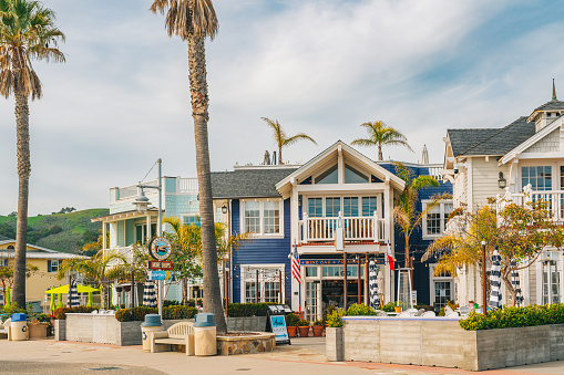 Avila Beach, California, USA - February 2, 2023.  Avila Beach city promenade filled with restaurants, shops, patios, benches, and art.