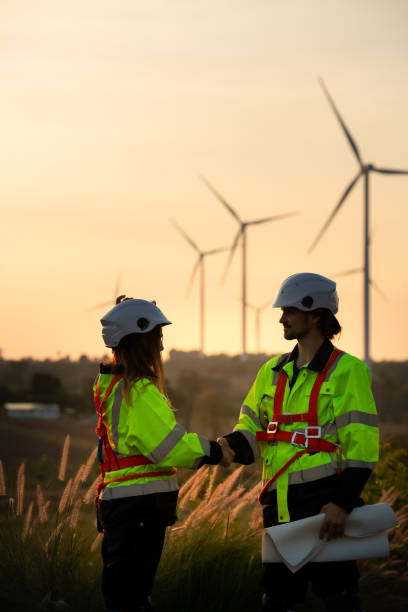 istock Engineers working on wind farms for renewable energy are responsible for maintaining large wind turbines. Review all tasks of the day while the evening sun shines a beautiful golden light upon both of them 1465739532