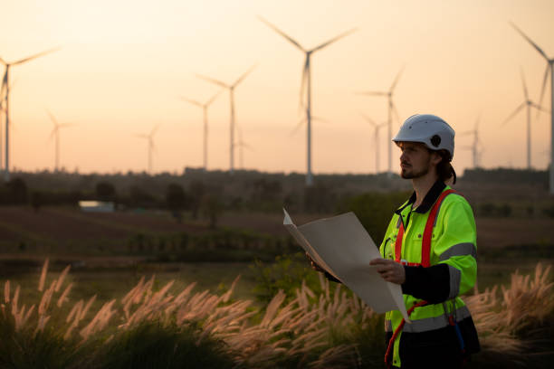 istock Engineers working on wind farms for renewable energy are responsible for maintaining large wind turbines. Review all tasks of the day while the evening sun shines a beautiful golden light upon both of them 1465740075