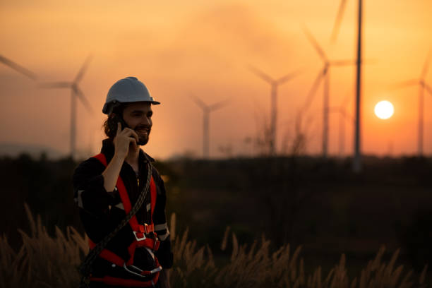 istock Engineers working on wind farms for renewable energy are responsible for maintaining large wind turbines. Review all tasks of the day while the evening sun shines a beautiful golden light upon both of them 1465740830