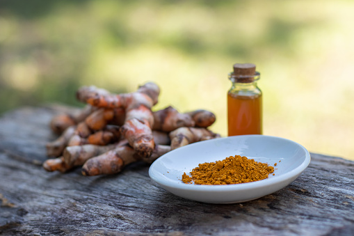 Turmeric, essential oil on wooden background. spa concept.