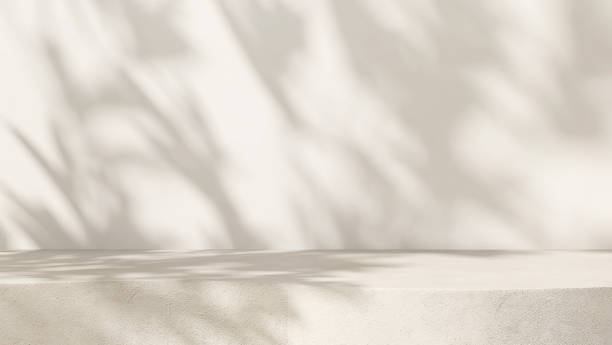 istock Blank cream white cement curve counter podium with texture, soft beautiful dappled sunlight, leaf shadow on white wall 1465749901