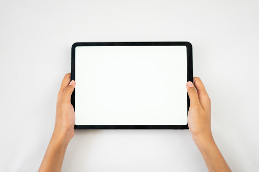 Two hands holding the tablet with a blank screen