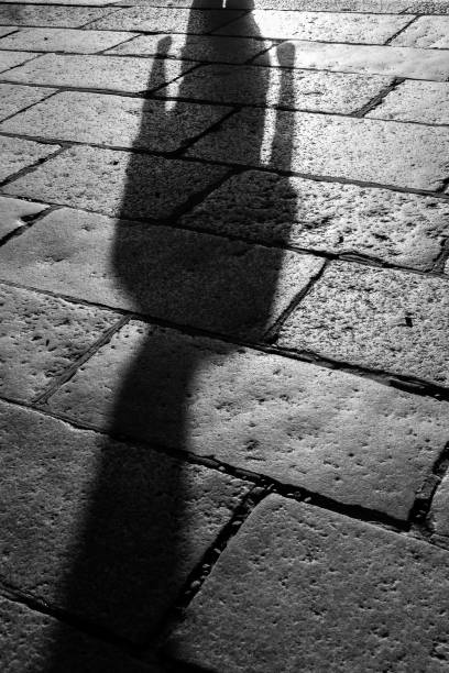 istock Image of people's shadows and stone pavement spreading in the setting sun 1465751753