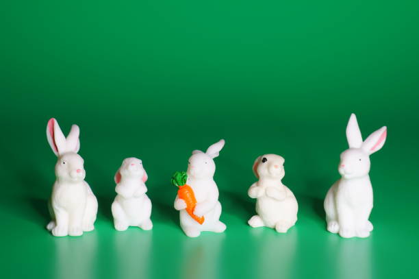 istock Figures of toy rabbits on a green background. 1465753302