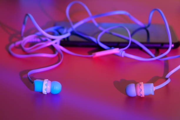 istock Wired headphones with a smartphone on a purple background. 1465753352
