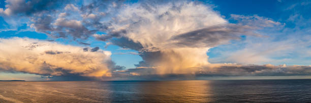 istock Panorama of dramatic storm cell with rain at sunset over the open ocean 1465754057