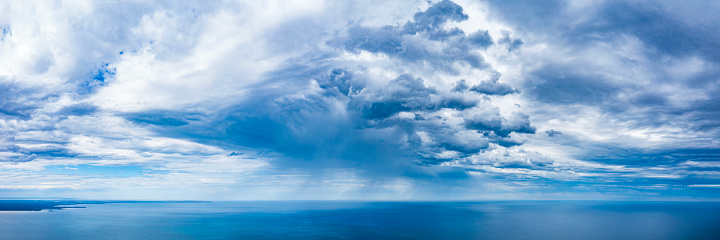 Panorama of dramatic storm cell with rain over the open ocean