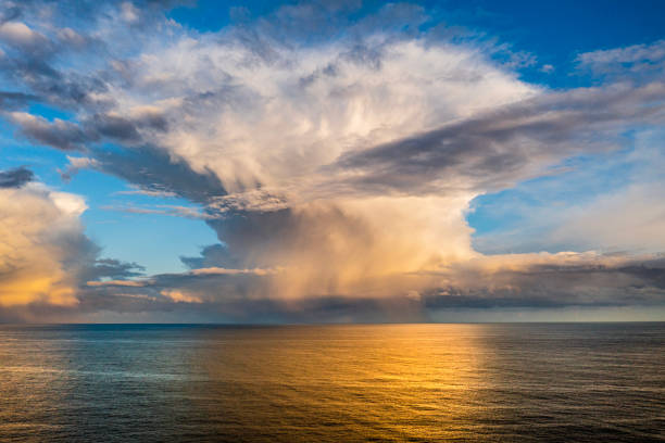 istock Dramatic storm cell with rain at sunset reflecting over a smooth ocean 1465754085