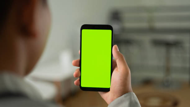 istock Man holding smartphone in shoulder angle with living room backdrop 1465754900