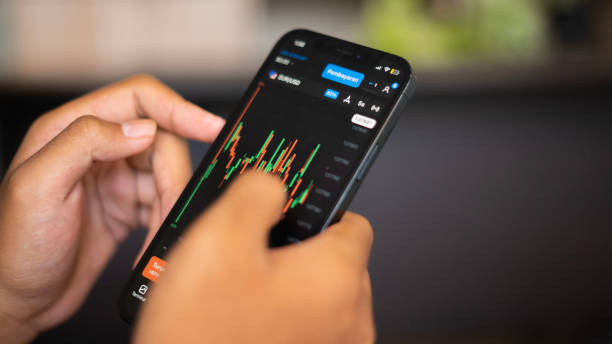 istock hands holding smartphone with stock exchange chart 1465754916