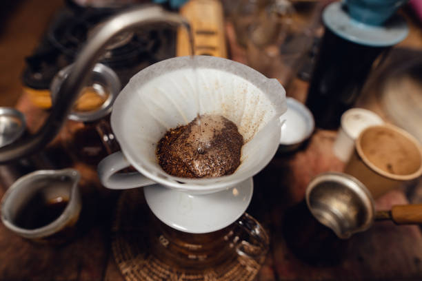 istock Man pouring hot water on ground coffee with paper filter to making a drip coffee 1465757952