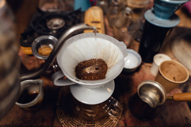 istock Man pouring hot water on ground coffee with paper filter to making a drip coffee 1465757965