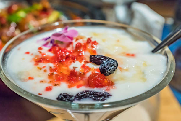 Yogurt served in a cocktail glass with raisins and petals