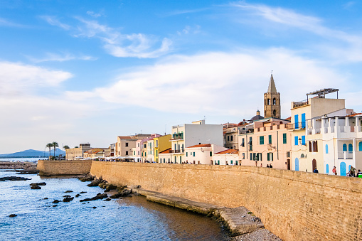 Tourists strolling along the Bastioni di Marco Polo in Alghero, the ramparts that are part of the 13th-century defense system and that still today surround the old town