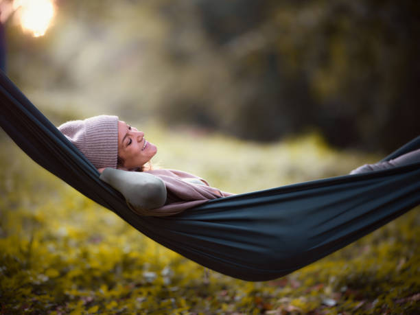 istock Happy woman relaxing in hammock at the backyard. 1465760985
