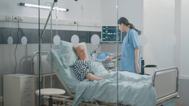 istock Woman nurse checking up on sleeping old patient in bed 1465761392