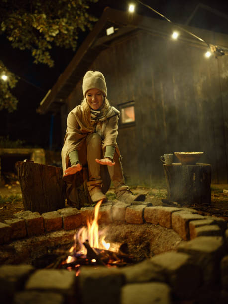 istock Happy woman warming herself during the night by the bonfire. 1465762288