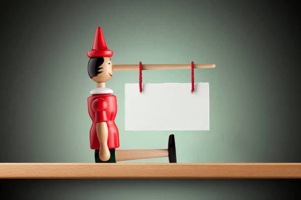 istock Lie. Pinocchio with blank placard hanging on the nose. 1465762294