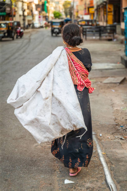 Young woman collecting plastic bottles from streets to sell it.