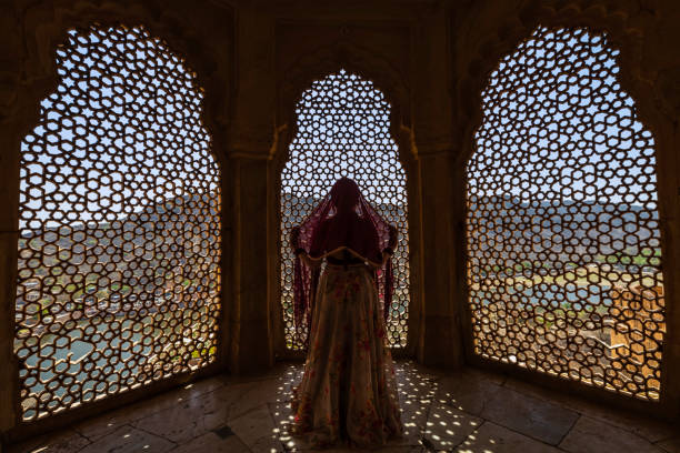 istock Young Indian woman looking through the window 1465764002