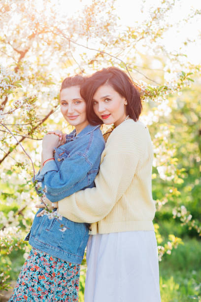 two little sisters sitting on the lawn in the city park. photo with a place for the text.
