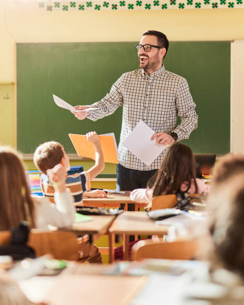 istock Happy male teacher giving a lecture at elementary school. 1465764426