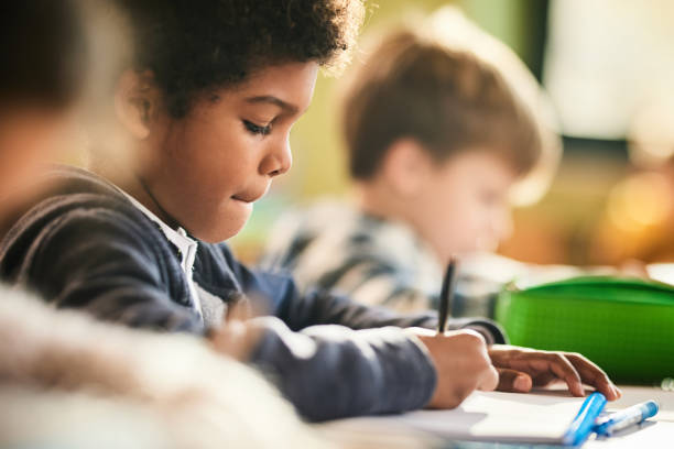 istock African American schoolboy writing a dictation during a class in elementary school. 1465764752