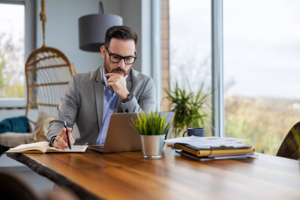 istock Portrait of businessman while using laptop in office, copy space 1465771313