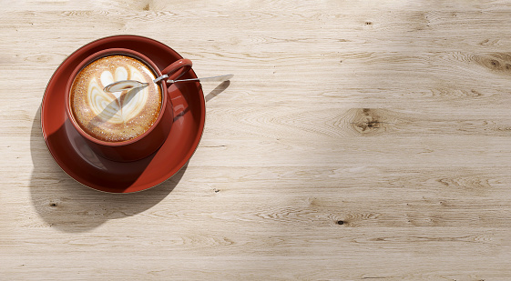 Top view of Beautiful heart shape latte art in maroon red ceramic coffee cup, saucer on wooden table with empty space in sunlight in cafe for love, food, drink, relaxation, health, energy product background