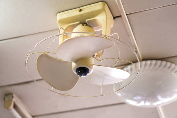istock A close-up photo shows a retro white ceiling fan hanging from an office ceiling. 1465783371