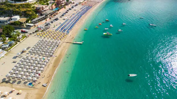 Aerial view of famous beach Valtos in amazing town Parga. Lot of lined parasols and sunbeds viewed directly above. Ionian sea, Greece