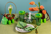 Easter table setting with hyacinths on a green linen tablecloth