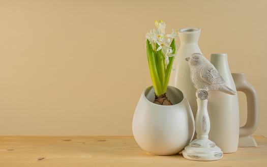 Spring Scandinavian cozy home decor: white vases, white hyacinth and bird figurines.