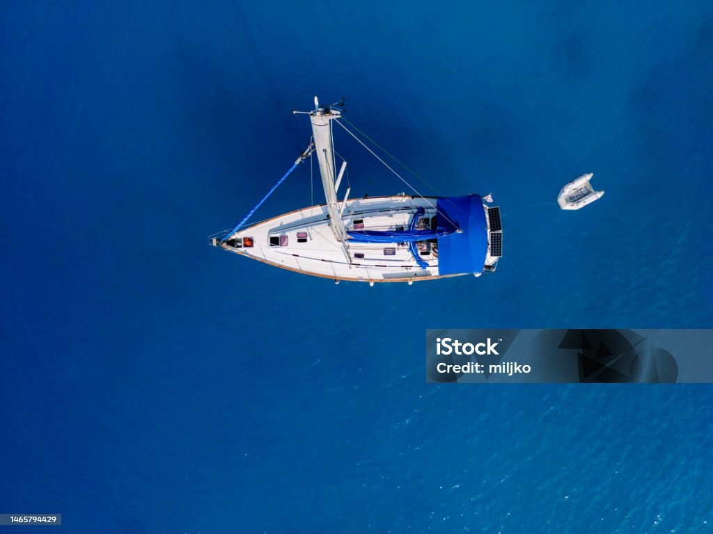 Sailboat moored on blue sea view from above Sailboat moored in bay with beautiful color of water. This bay is next to the one of the most popular beach on the world, recognizable by turquoise color of water. Aerial view photos made with drone. Porto Katsiki beach, Lefkada island, Greece Lefkada Island Stock Photo