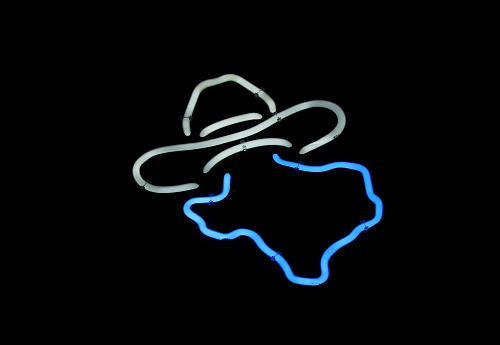 A scenic shot of a neon sign Texas with a cowboy hat