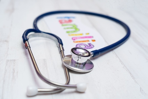 A closeup of a stethoscope and paper with Familia handwritten on it, healthcare concept