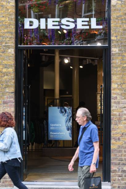 compradores passam por uma loja de roupas diesel em uma rua movimentada no centro de londres - raybans - fotografias e filmes do acervo