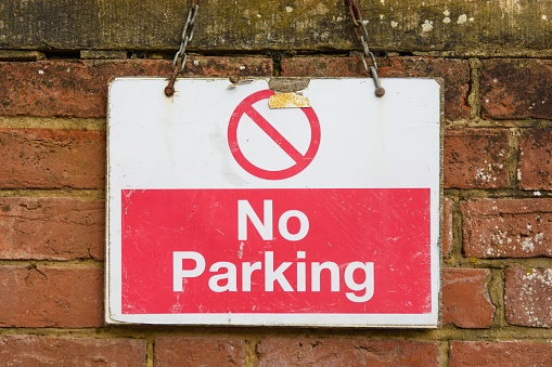 A no parking street sign at the side of the road informs drivers that they cannot park there.