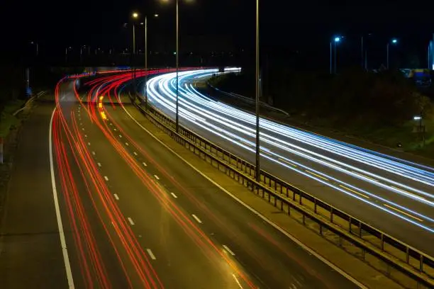 Night time photography picture of the M5 motorway with blurred vehicles and light trails created using slow shutter speeds.