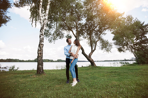 couple in love hugs standing on the lawn near the lake . love story.