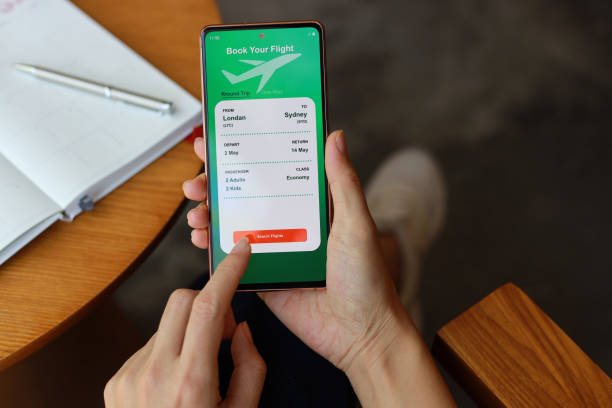 Woman using smartphone to book flight tickets and plan holiday stock photo