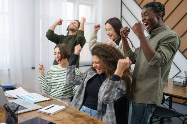 istock happy business team celebrating near the desktop. 1465802341