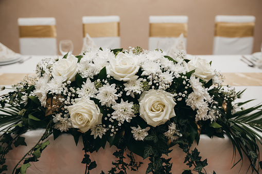 A beautiful white floral arrangement on a venue table