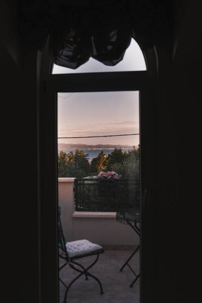 istock Door opening to a balcony view with the sun setting behind the clouds 1465807087
