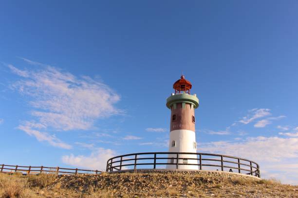 istock Beautiful lighthouse atop a hill overlooking the ocean 1465807151