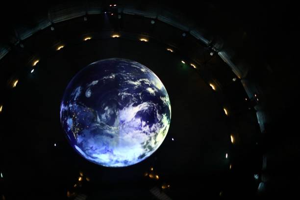 istock Planet earth model in the dark with spotlights around it 1465809204